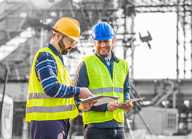 Two construction workers reviewing building plans.