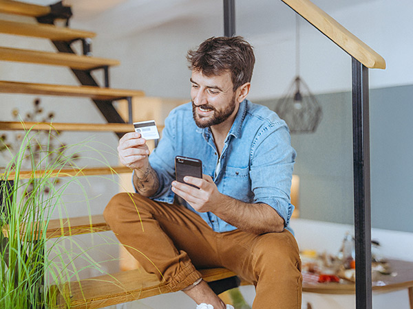 Man using debit card with cell phone